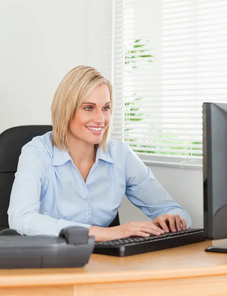 Arbetande blond kvinna framför en skärm att titta på det — Stockfoto