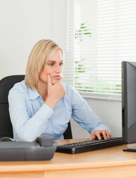 Pracující žena před obrazovkou při pohledu na to — Stock fotografie