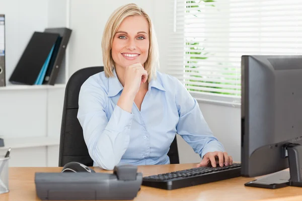 Working cute woman in front of a screen looking into camera — Stock Photo, Image