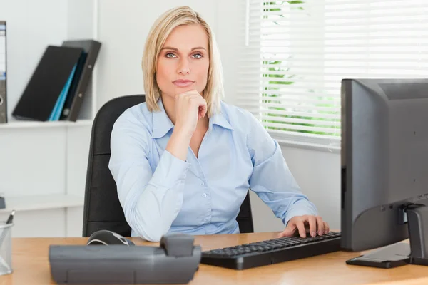 Trabajar mujer seria delante de una pantalla mirando a la cámara — Foto de Stock