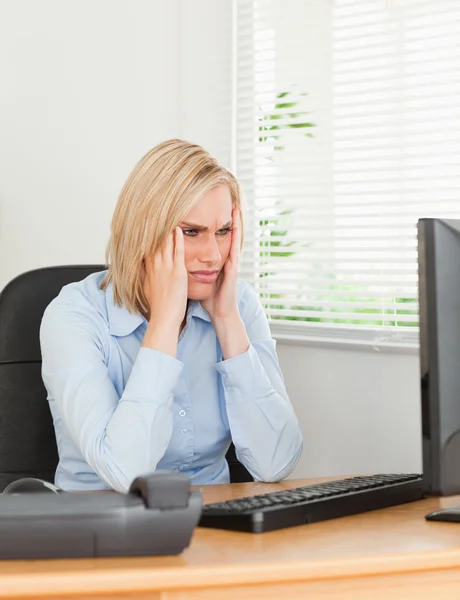 Frustrerad arbetande kvinna tittar på en skärm — Stockfoto