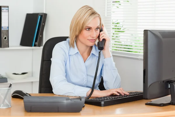 Glimlachende zakenvrouw op de telefoon kijken naar haar scherm — Stockfoto