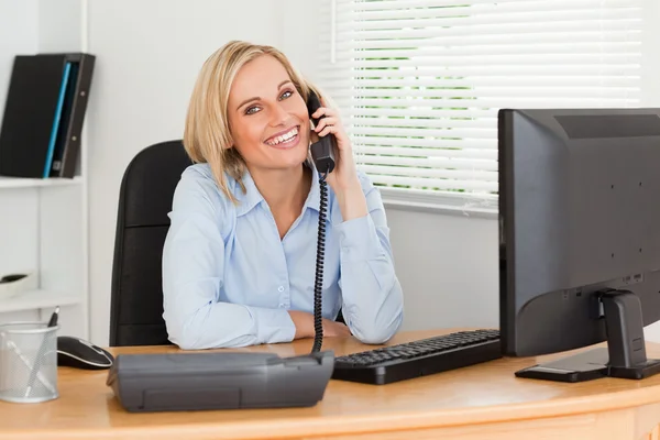 Cheerful businesswoman on phone looking into camera — Stock Photo, Image