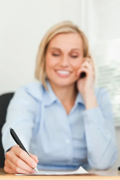 Portrait of a cute businesswoman on mobile noting something with — Stock Photo, Image