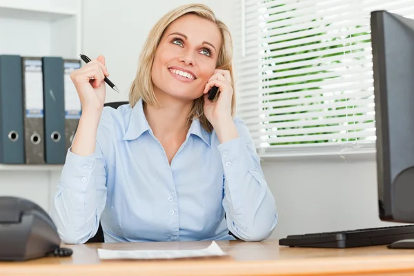 Portrait of a businesswoman smiling at the ceiling with pen in h — Stock Photo, Image