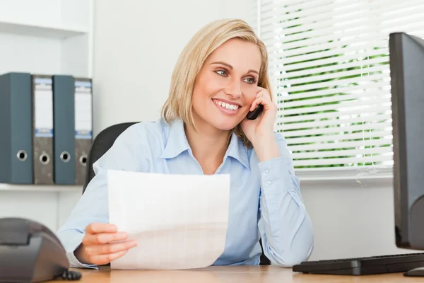 Portrait of a businesswoman looking up from a letter to her scre — Stock Photo, Image