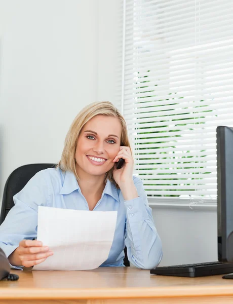 Portrait of a businesswoman looking up from a letter into camera — Stock Photo, Image