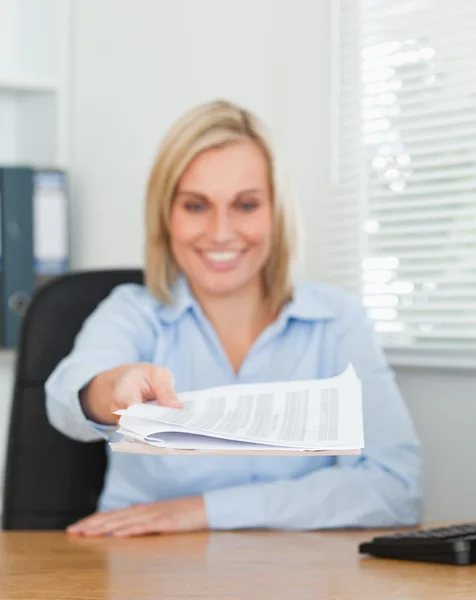 Lachende blonde zakenvrouw passeren een papier te kijken — Stockfoto