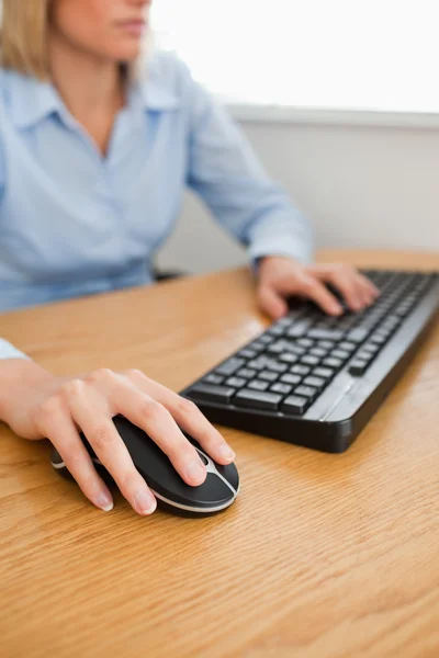 Blonde zakenvrouw met handen op muis en toetsenbord — Stockfoto