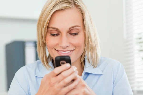 Leende kvinna som tittar på sin mobil — Stockfoto