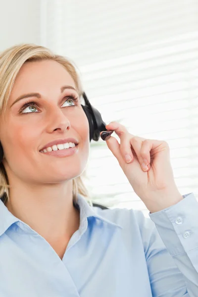 Smiling businesswoman with headset looking at the ceiling — Stock Photo, Image