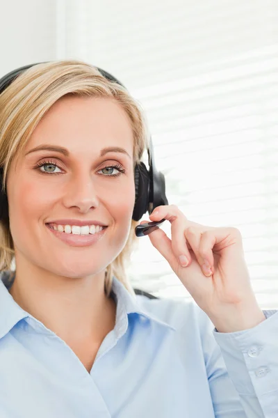 Glimlachende zakenvrouw met headset op zoek naar camera — Stockfoto