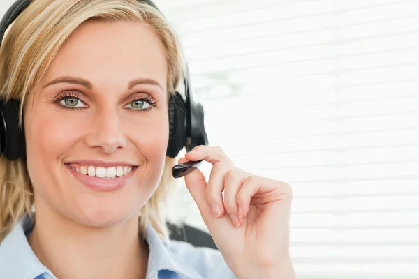 Close up de uma empresária sorridente com fone de ouvido olhando para ca — Fotografia de Stock