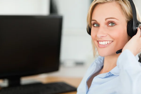 Retrato de una mujer de negocios rubia sonriente con auriculares funcionando — Foto de Stock