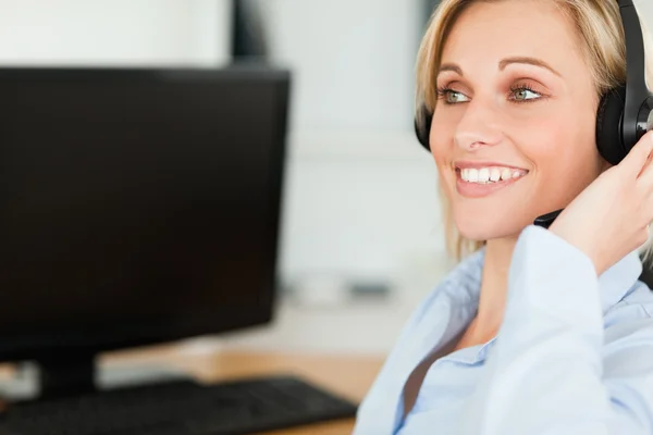 Retrato de uma empresária sorridente com fone de ouvido trabalhando com co — Fotografia de Stock