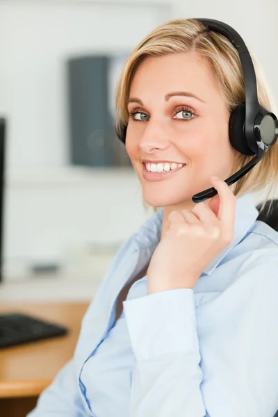 Portrait of a smiling businesswoman with headset lookinginto cam — Stock Photo, Image