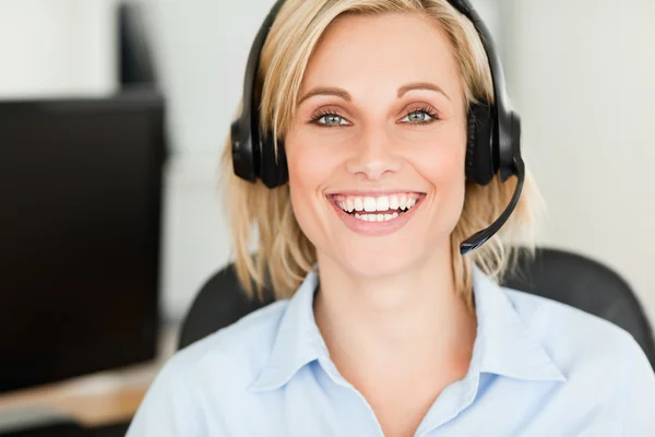 Close up of a blonde woman wearing headset looking into camera — Stock Photo, Image
