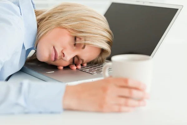 Πανέμορφη γυναίκα στον ύπνο για το laptop με το φλυτζάνι του καφέ στο χέρι — Φωτογραφία Αρχείου