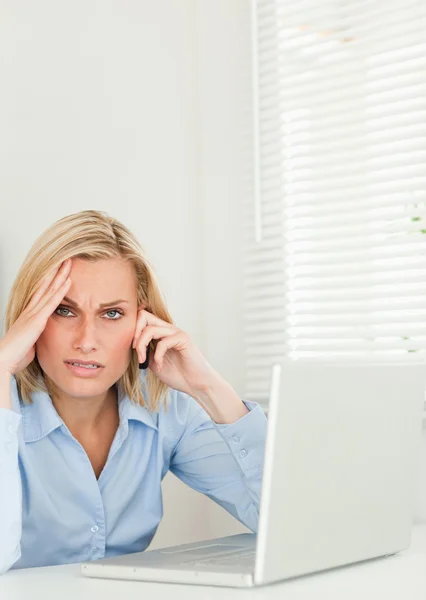 Frustrovaný blond podnikatelka sedí v přední části svého poznámkového bloku — Stock fotografie