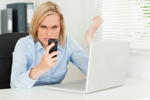 Mujer de negocios mirando fijamente su teléfono — Foto de Stock
