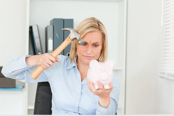 Determined woman wanting to destroy her piggy bank — Stock Photo, Image