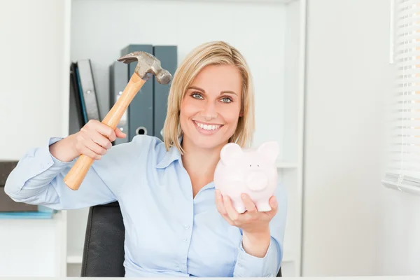 Expectantly woman wanting to destroy her piggy bank — Stock Photo, Image