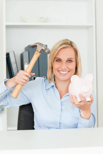 Happy woman wanting to destroy her piggy bank — Stock Photo, Image