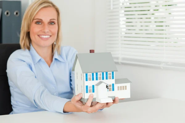 Mulher mostrando modelo casa — Fotografia de Stock