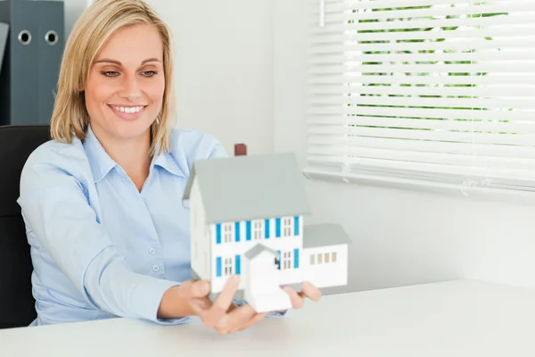 Vacker affärskvinna presentera modell hus ser på det — Stockfoto
