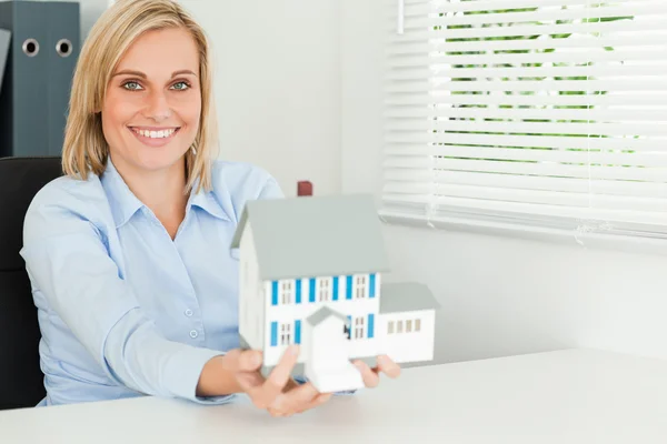 Vacker affärskvinna presentera modell hus ser in i kameran — Stockfoto