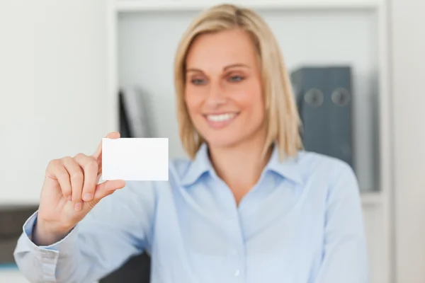 Blonde businesswoman holding a card — Stock Photo, Image