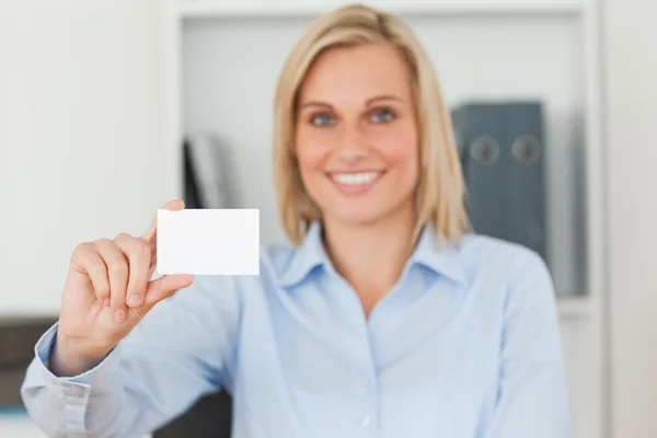 Blonde businesswoman holding a card looks itno camera — Stock Photo, Image