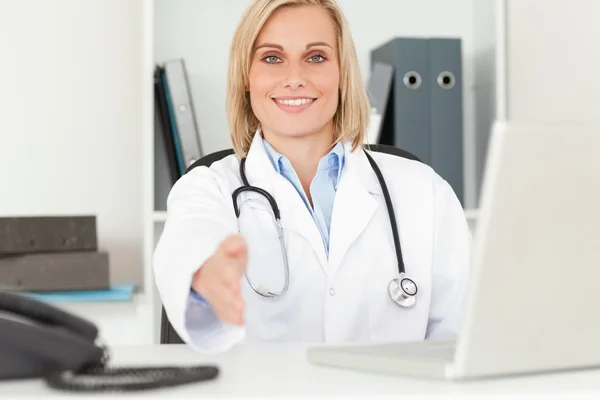 Blondynka uśmiechający się lekarz podając rękę — Zdjęcie stockowe