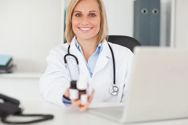 Médico sonriente sosteniendo medicina — Foto de Stock