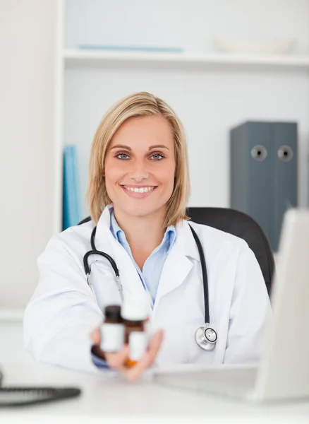 Médico sonriente mostrando medicina — Foto de Stock
