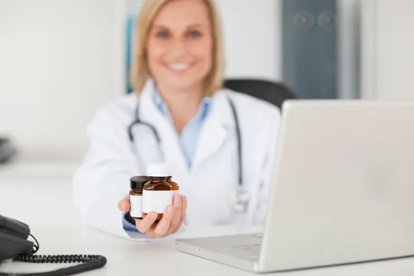 Médecin blond souriant présentant des médicaments — Photo