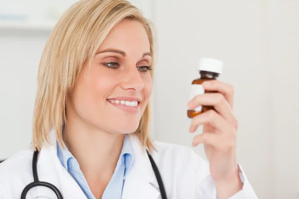 Улыбающийся доктор смотрит на медицину — стоковое фото