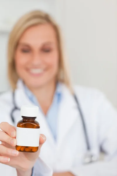 Médico sonriente sujetando la medicina a la cámara — Foto de Stock