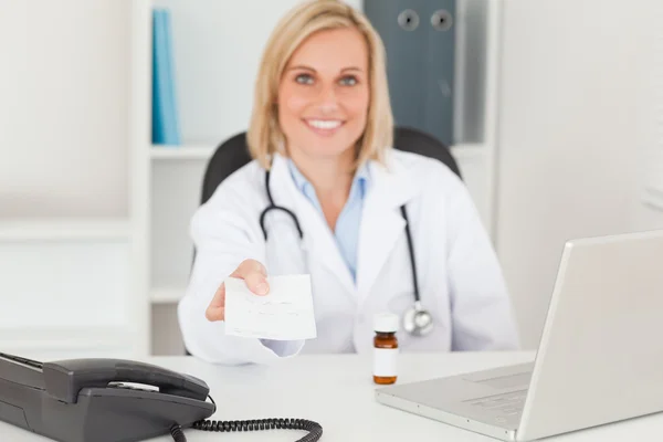 Médico sorridente segurando prescrição — Fotografia de Stock