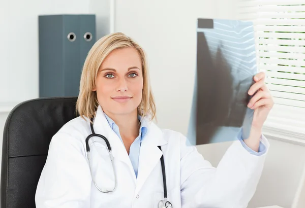 Charmiga läkare håller röntgen ser in i kameran — Stockfoto