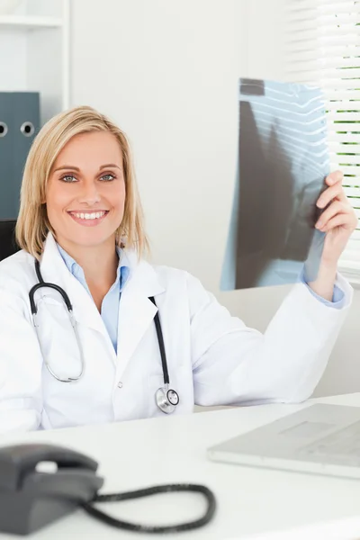Очаровательный доктор, держащий рентгеновские улыбки в камере — стоковое фото