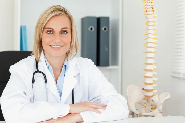 Leende läkare med modell ryggraden bredvid henne — Stockfoto