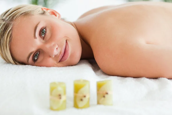 Blondýna usměvavá žena ležící na masážní lehátko — Stock fotografie