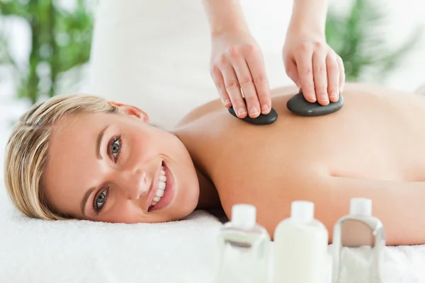 Blonde smiling woman experiencing a stone therapy — Stock Photo, Image