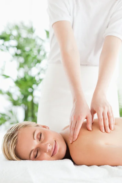Linda mulher sorridente relaxante em uma espreguiçadeira durante a massagem com — Fotografia de Stock