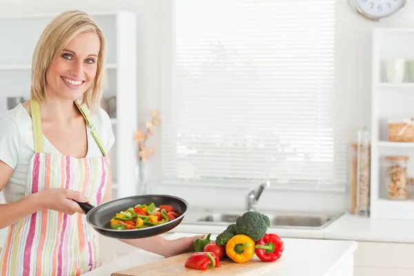 Mulher mostrando pimentas cortadas na panela — Fotografia de Stock