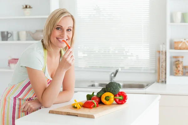 Retrato de uma mulher comendo pimentas vermelhas — Fotografia de Stock