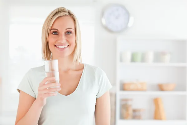 Sonriente mujer sosteniendo vaso de agua — Foto de Stock