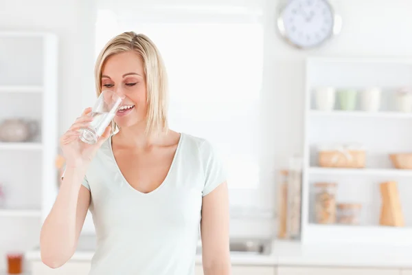 Mulher encantadora bebendo água de pé — Fotografia de Stock