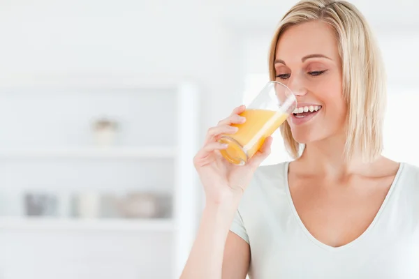 Mujer sonriente bebiendo jugo de naranja — Foto de Stock